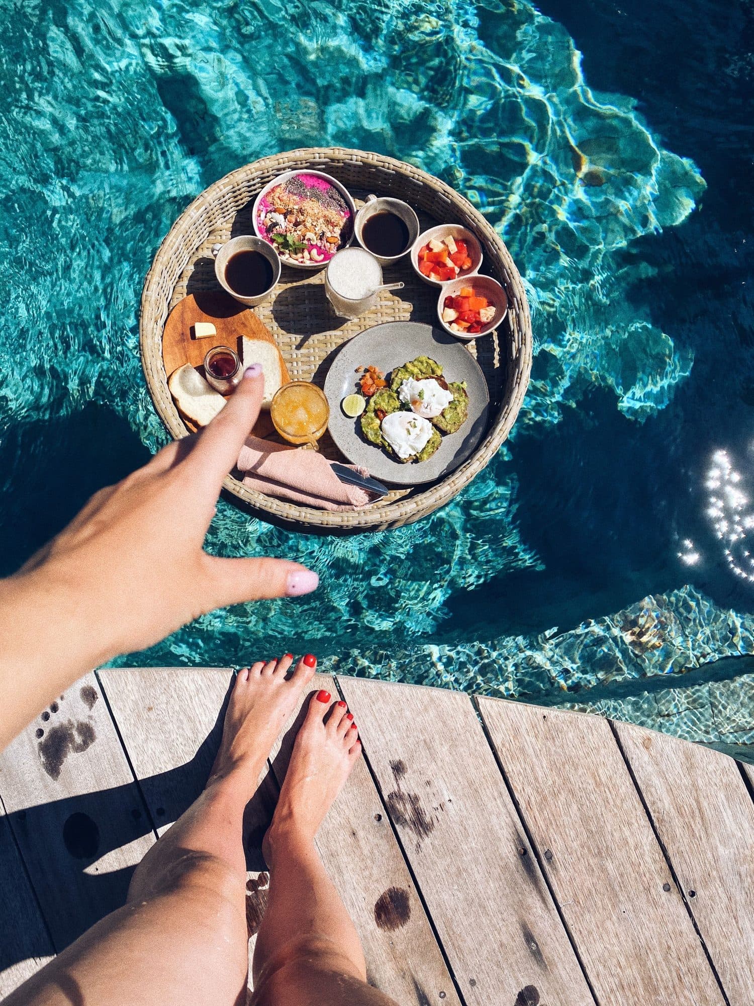 Floating breakfast tray in a sunny tropical villa pool, the kind of guest-view moment hotel UGC captures