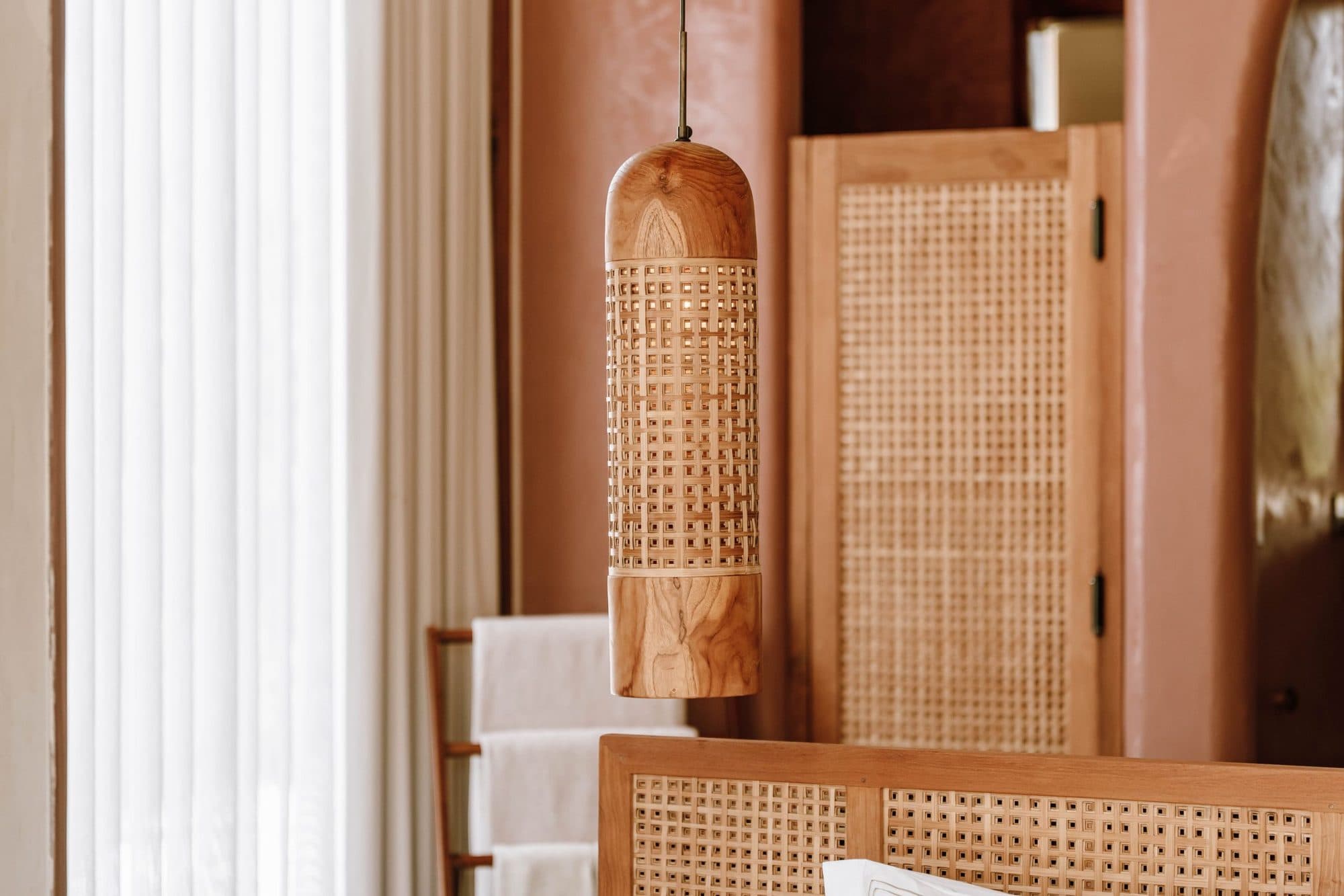 Rattan wardrobe panel and soft curtains in a terracotta room